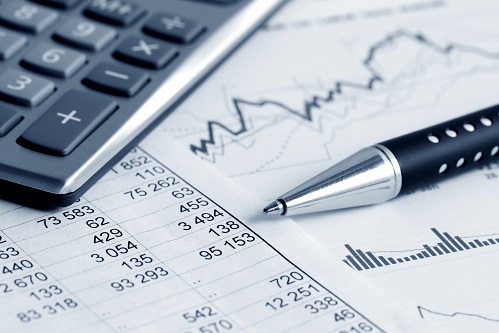 Keyboard, data, a graph, and a pen on a table.