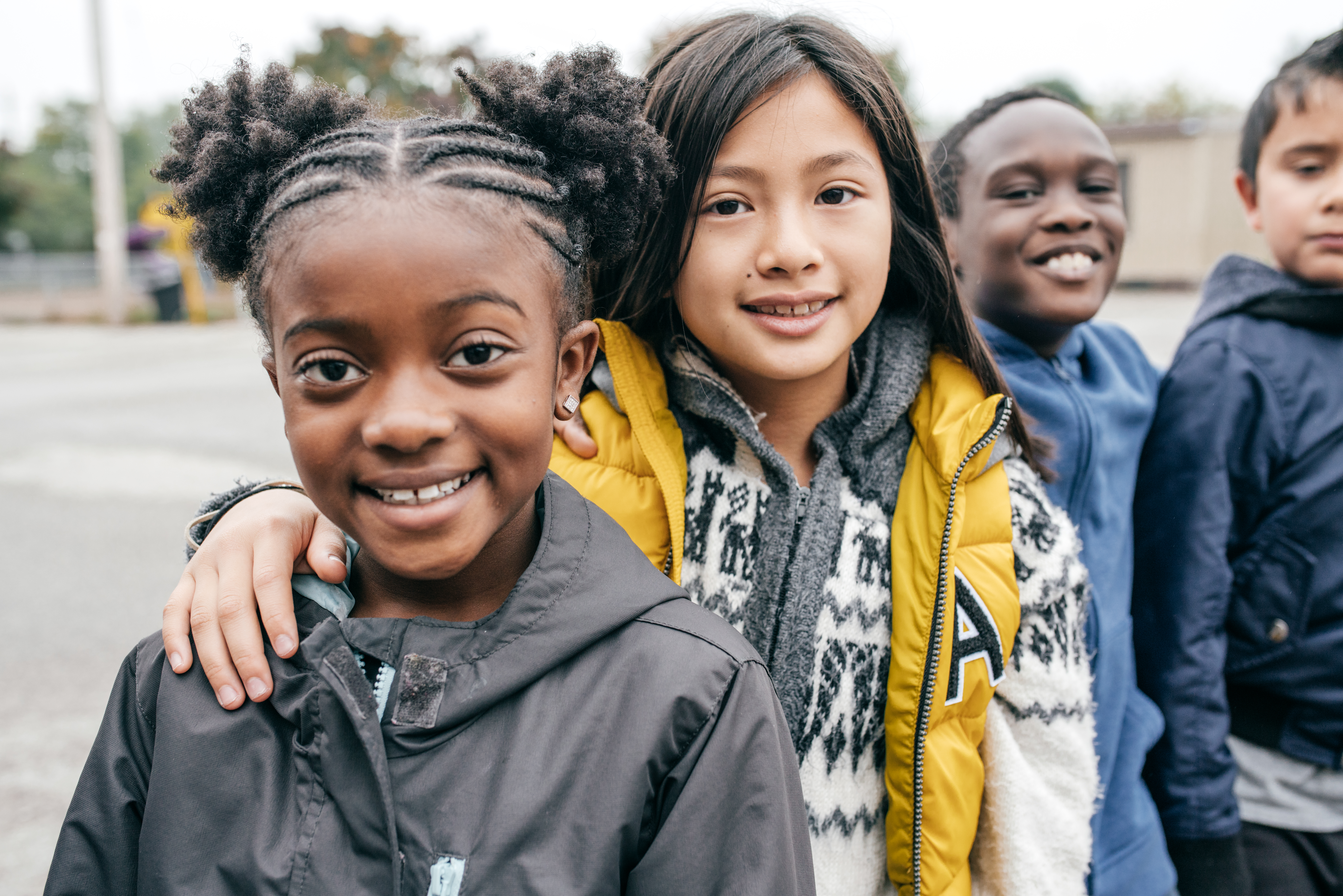 Children standing on a playground smiling
